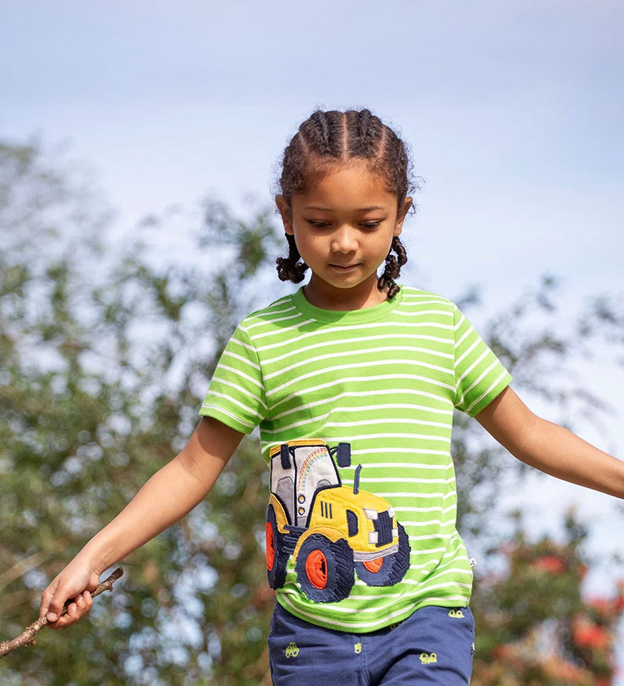 Achild wearing the Frugi kids sid t-shirt - GOTS organic cotton kids short sleeve t-shirt in green and white stripe with a yellow tractor appliqué to the left side