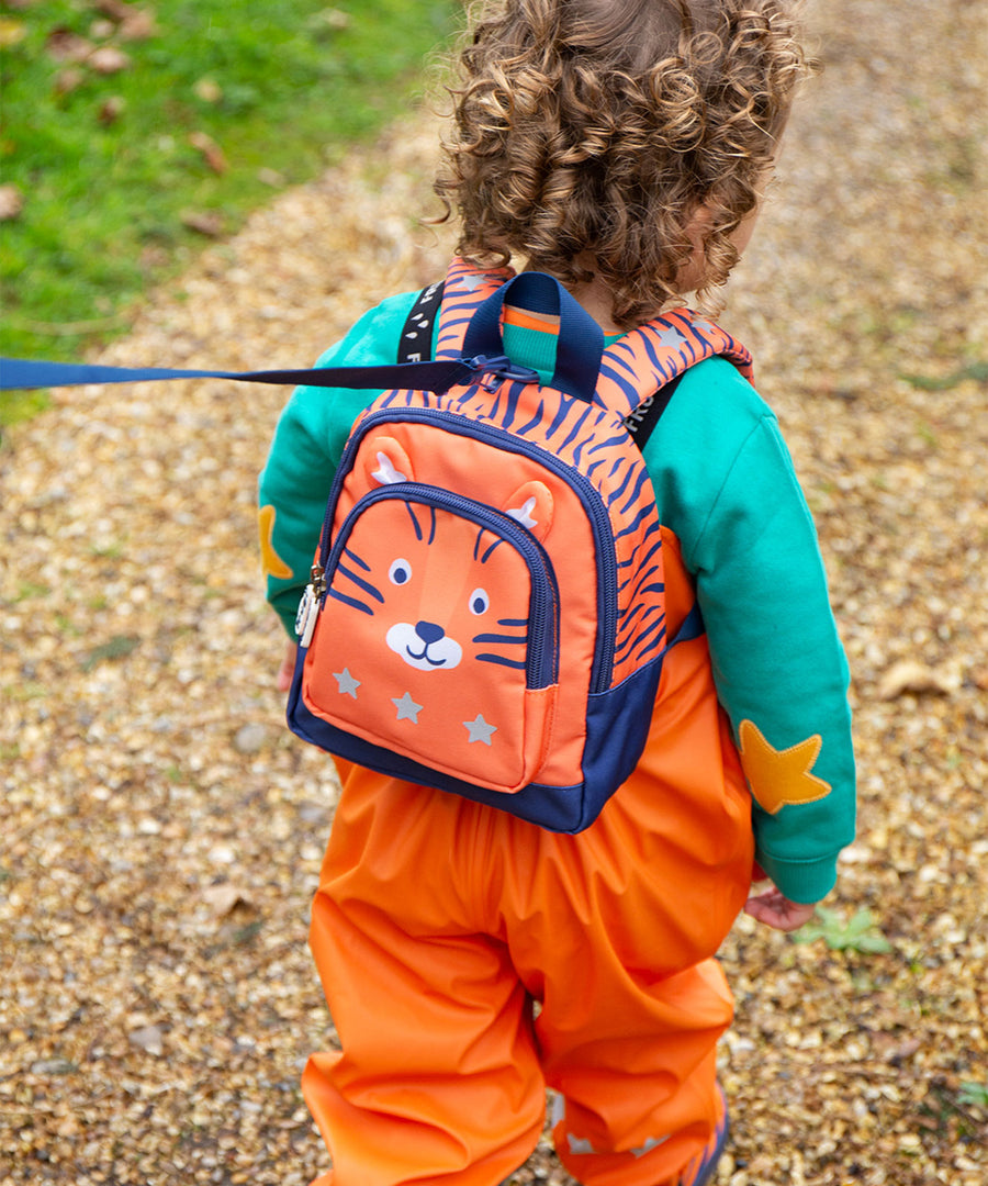  this Little Adventurers Backpack from Frugi comes in an orange and navy blue Tiger print. This bag has a interactive tiger ears