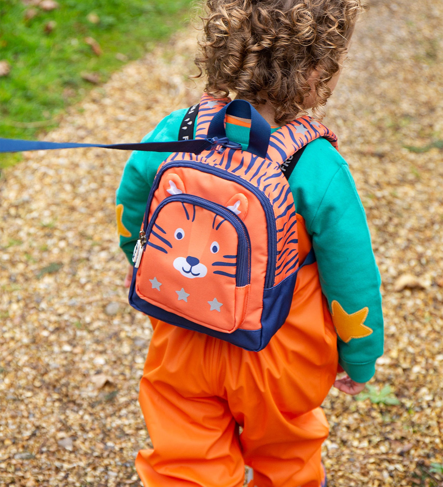  this Little Adventurers Backpack from Frugi comes in an orange and navy blue Tiger print. This bag has a interactive tiger ears