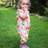 A child wearing the Frugi Paint A Floral Lula organic cotton Playsuit