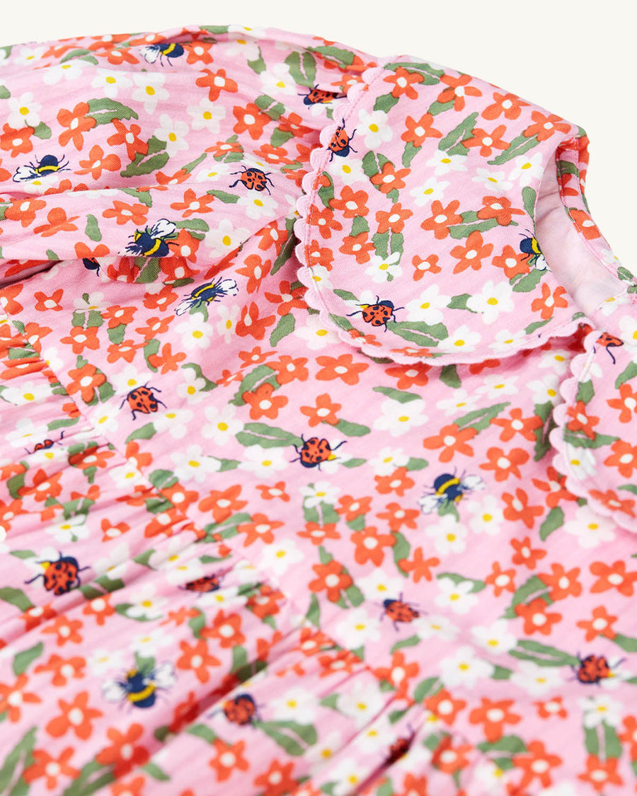  bees and ladybirds on a light pink fabric. The dress is a Tiered Dress with oversized peter pan collar and puff sleev