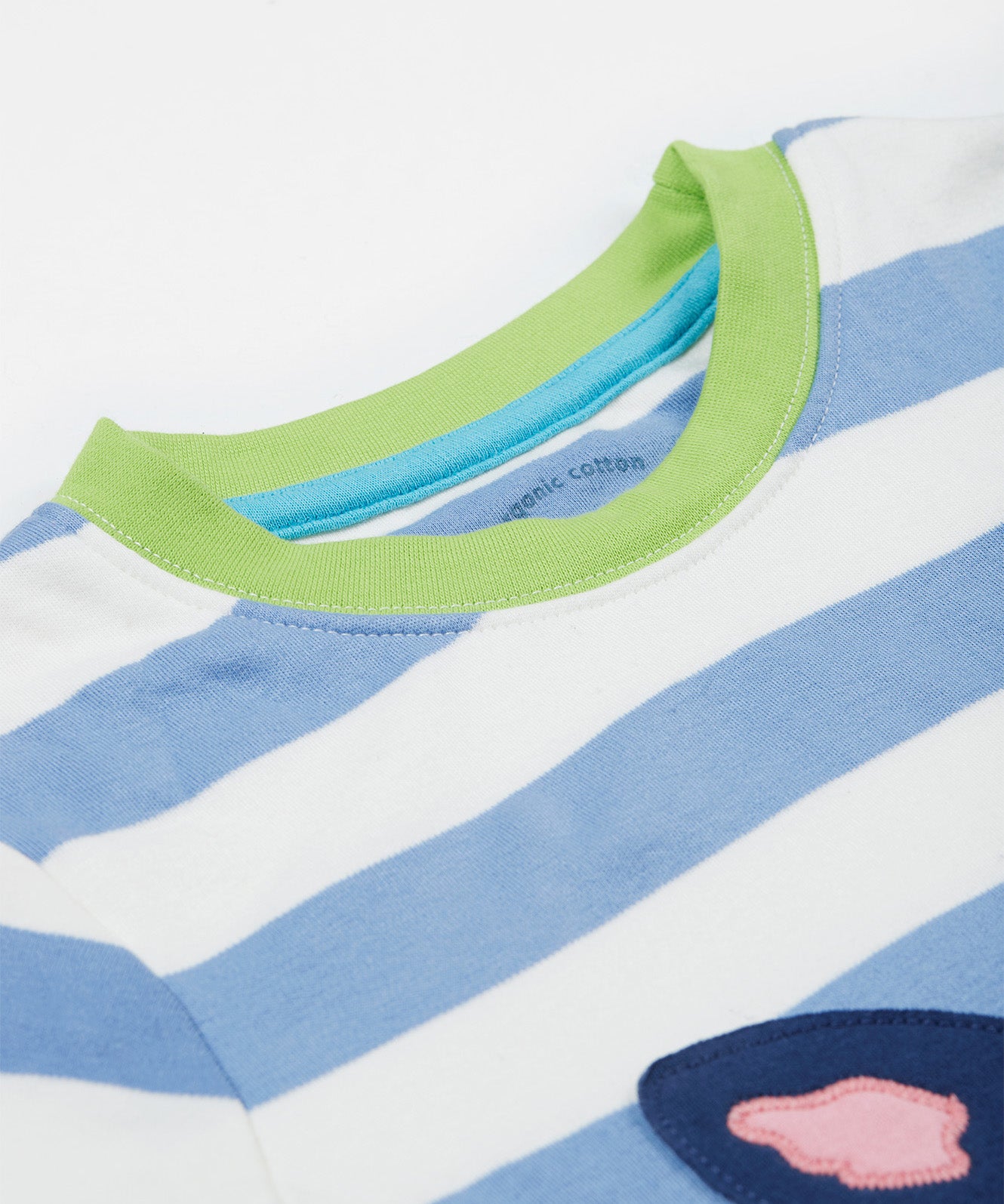 A close up of the Frugi kids Porth collie dog pyjama set showing the green neck trim on a blue and white striped organic cotton fabric