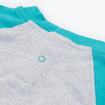 Close up of the Frugi kids koala raglan t-shirt. Showing the popper fasteners on the back for easy fitting on grey and blue organic cotton fabric