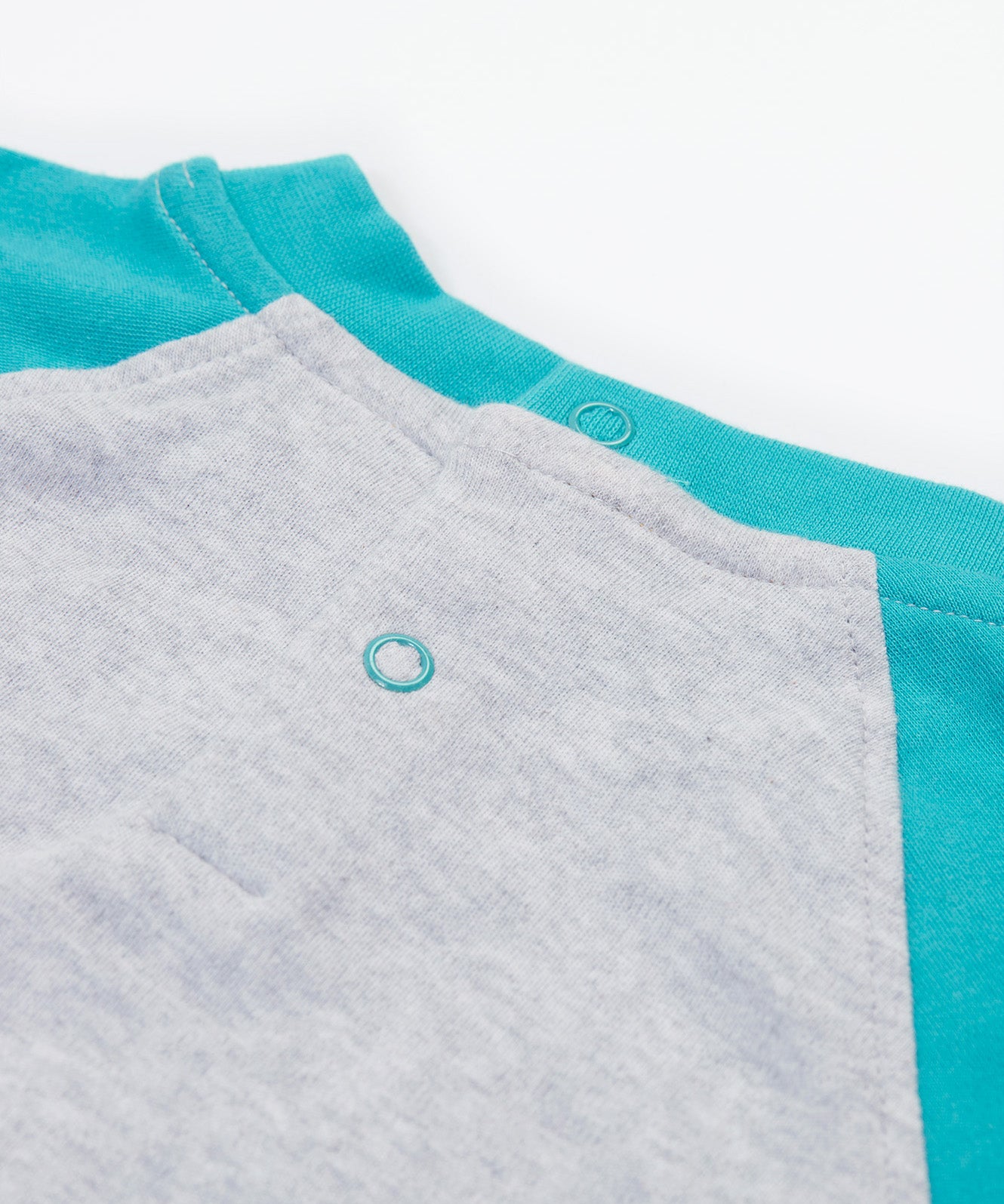 Close up of the Frugi kids koala raglan t-shirt. Showing the popper fasteners on the back for easy fitting on grey and blue organic cotton fabric