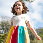 A child wearing the Frugi Rainbow Jersey Dress.