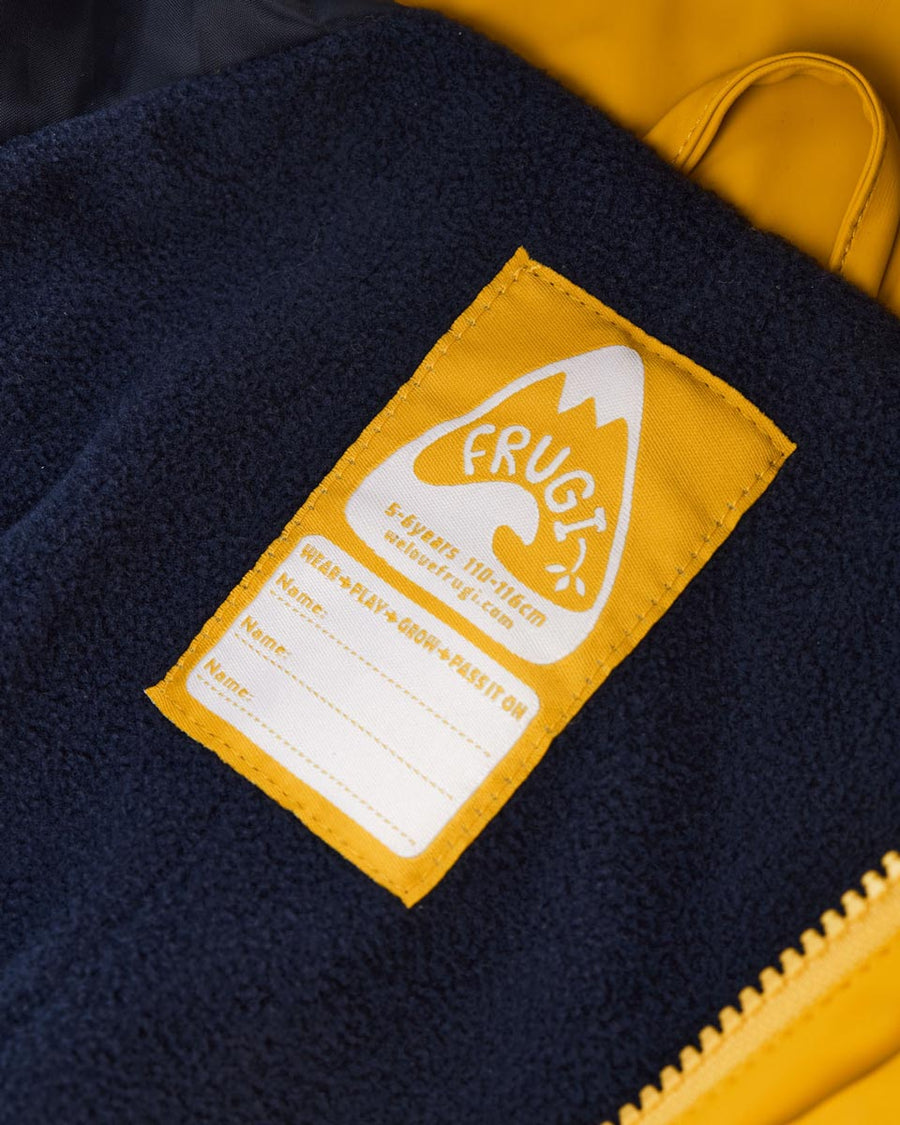 Close up of the name label on the Frugi recycled plastic puddle buster all in one suit