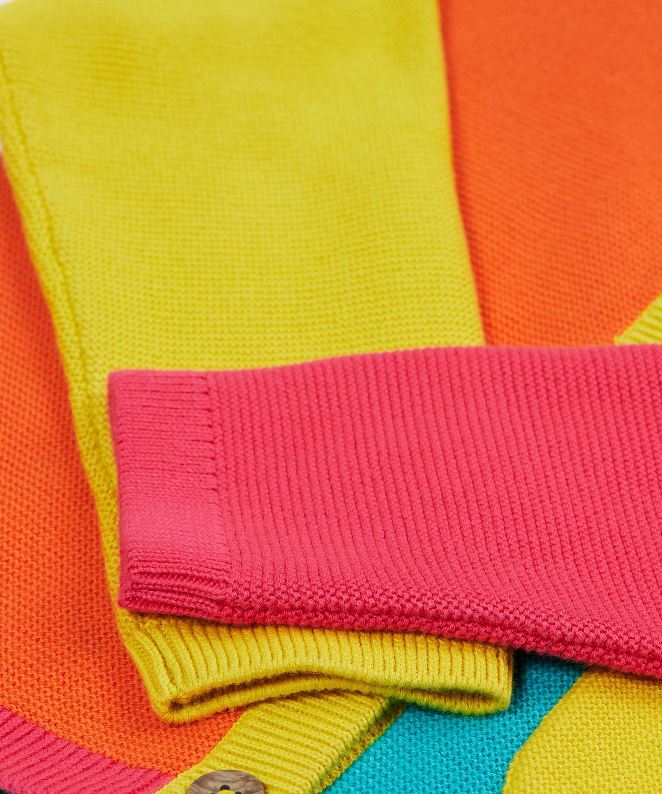 Close up of the Frugi kids Rose pocket cardigan, happy pen pot. Showing the pink and yellow arm cuff on organic knitted cotton fabric