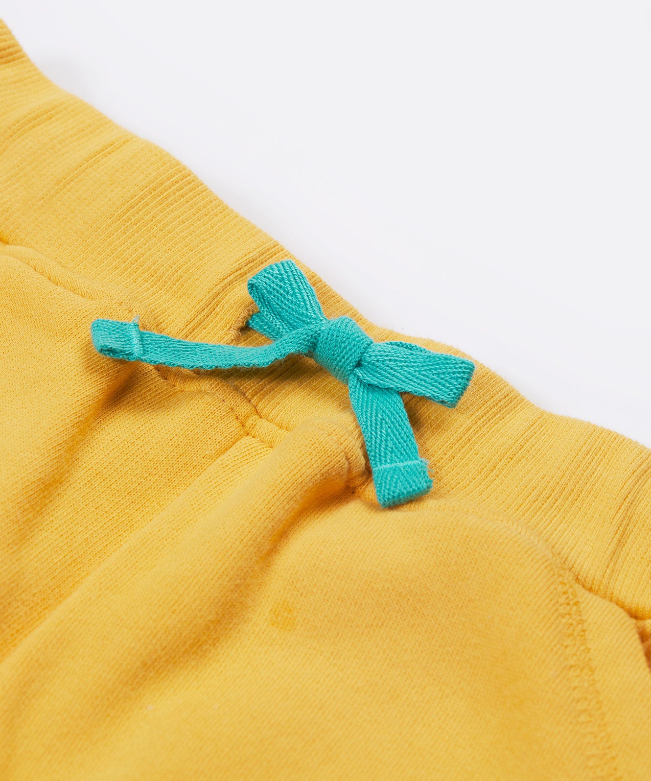 Close up of the Frugi kids bumblebee Samson shorts showing the turquoise waist drawstring on yellow organic cotton fabric