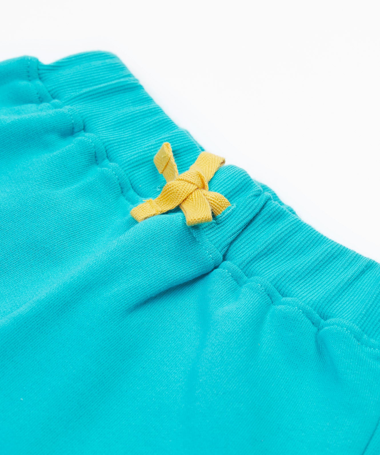 Close up of the Frugi kids koala shorts showing the yellow waist drawstring on blue organic cotton fabric