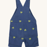 Frugi baby short navy tractor dungarees - GOTS organic cotton baby dungarees in navy blue showing the shoulder strap back detail. Features a green tractor embroidery all over the dungarees.