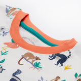 A close up of the Frugi kids snooze wildlife pyjama set showing the prints of different wild animals and orange neck trim on white organic cotton fabric