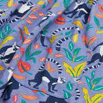 Close up of the Frugi kids summer holiday dress lemur laughs. Showing the lemurs on the bottom half surrounded by different coloured leaves   and front pocket detail on purple organic cotton fabric