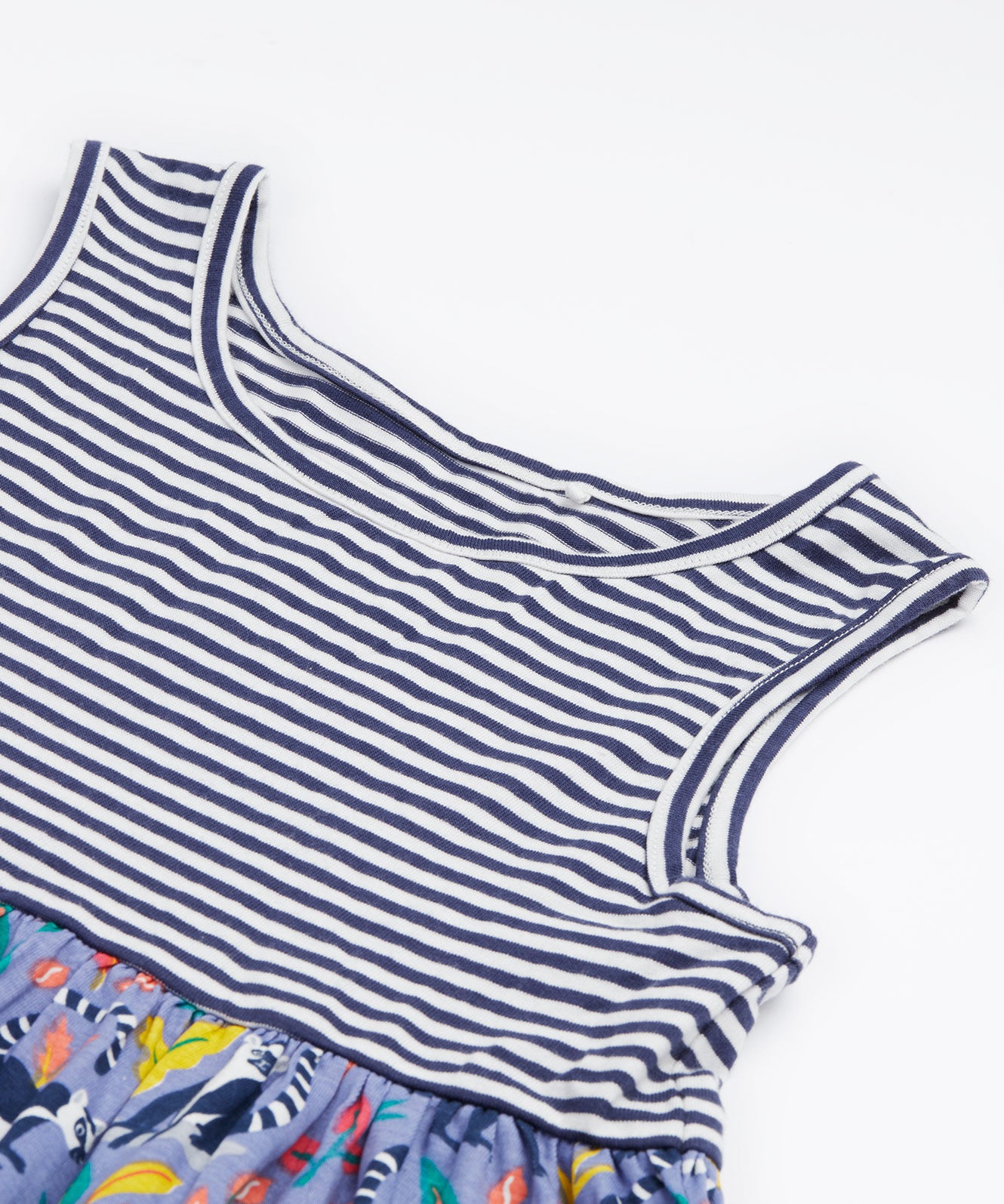 Close up of the Frugi kids summer holiday dress lemur laughs. Showing the sleeveless and neck detail on navy and white stripe organic cotton fabric. 