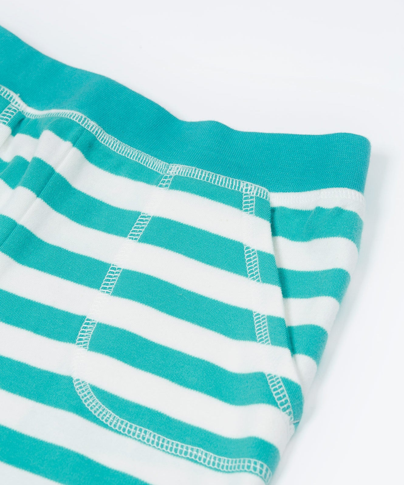 Close up of the Frugi kids sunny sea moss short - showing the front pocket and blue waist band on blue and white stripe organic cotton fabric