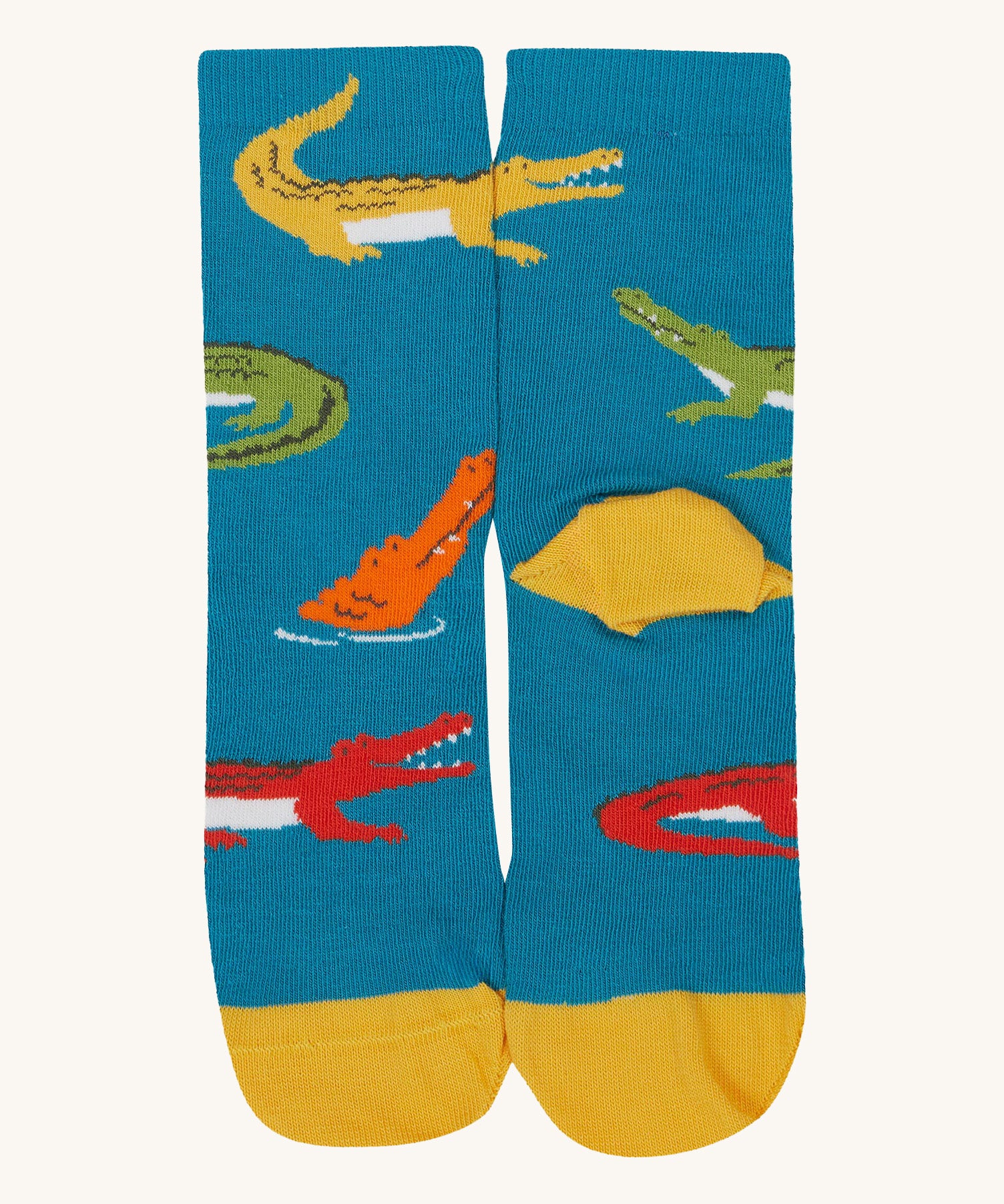 A close up of the Frugi teal multicoloured crocodile sock a soft GOTS cotton sock features a yellow sole and toes panel