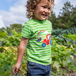 A child wearing a Frugi Tractor Applique  Easy On T-Shirt with denim shorts