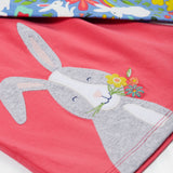 Close up of the Frugi kids watermelon iris bunny outfit. Showing the grey rabbit appliqué detail with light blue bottoms with white rabbits and floral prints on top on organic cotton fabric.