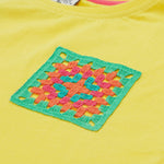 Close up of the Frugi kids yellow crochet pocket t-shirt. Showing the neck trim and the green, orange and blue crochet front pocket on yellow organic cotton fabric