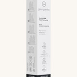 Side view of the Georganics activated charcoal hydroxyapatite toothpaste cardboard packaging, white with grey and black  text showing the instructions and features.