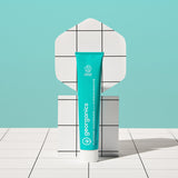 Front view of the Georganics fresh mint hydroxyapatite toothpaste tube on a tile style floor and matching light green background.