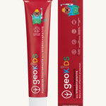 Front view of the Georganics strawberry hydroxyapatite toothpaste. A red tube with white branding text and a playful beaver design next to matching cardboard packaging. 