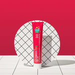 Front view of the Georganics strawberry hydroxyapatite toothpaste tube on a tile style floor and matching red background.