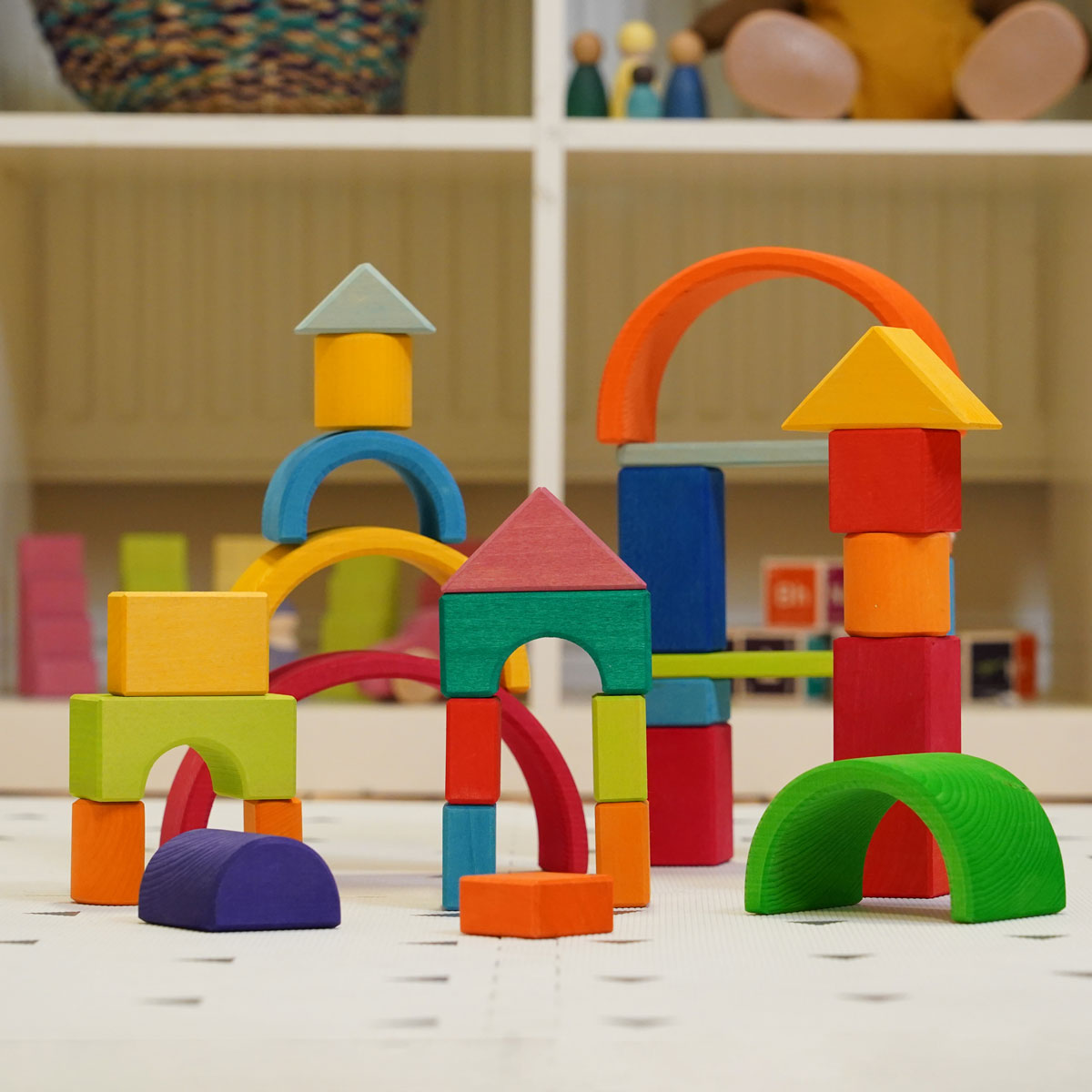 Glückskäfer 27 Piece Building Blocks Set pictured in a playroom alongside the Grimm's 6 piece rainbow