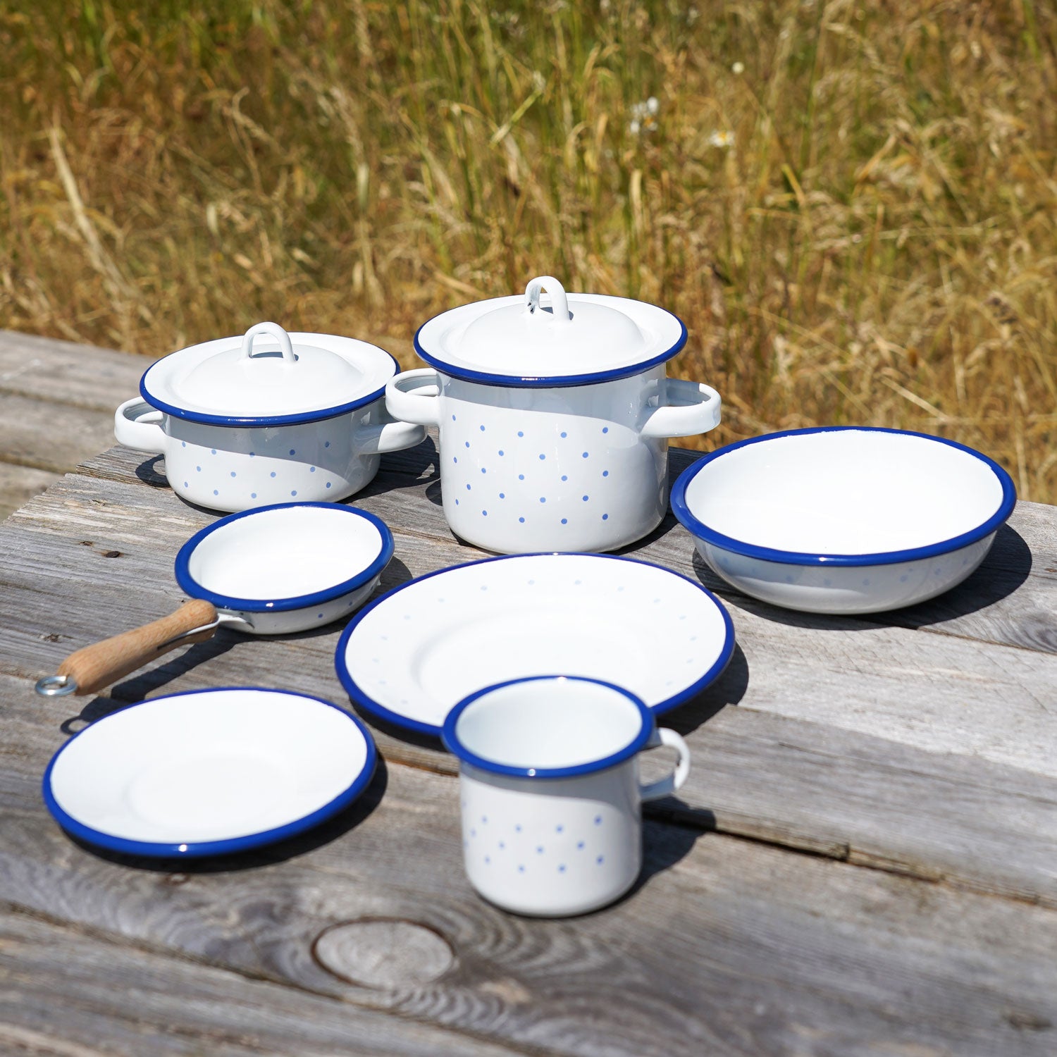 A collection of Glückskäfer Enamel toys pictured on a wooden surface outdoors