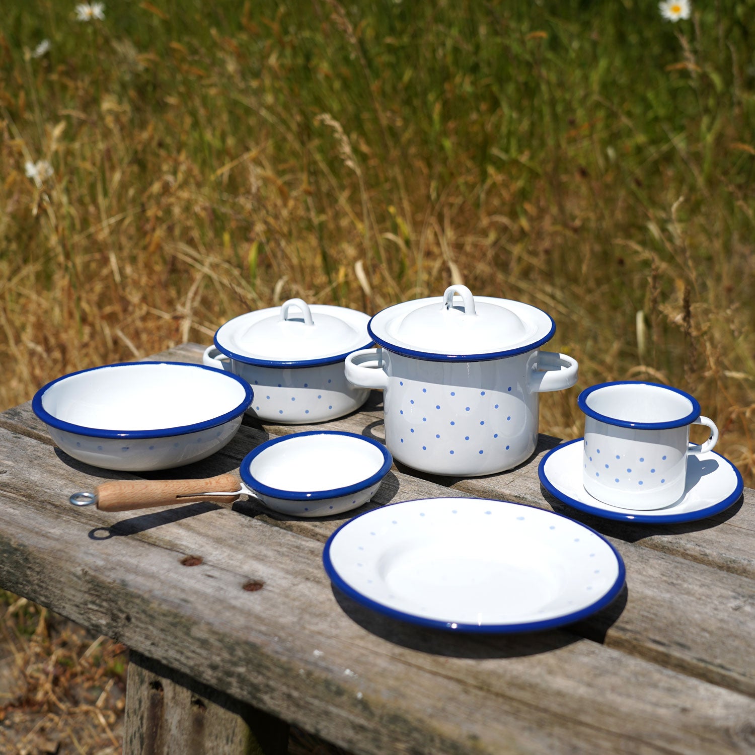 A collection of Glückskäfer Enamel toys pictured on a wooden surface outdoors