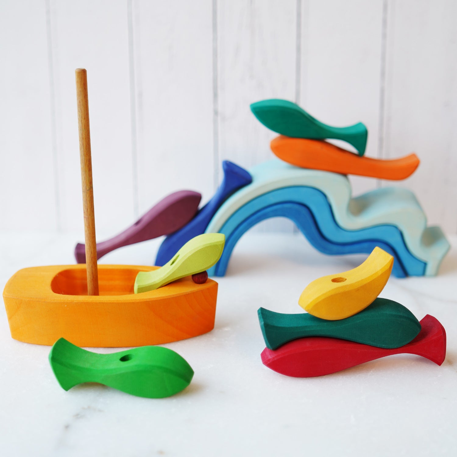 and sizes of fish. The set includes a wooden boat with a sail.