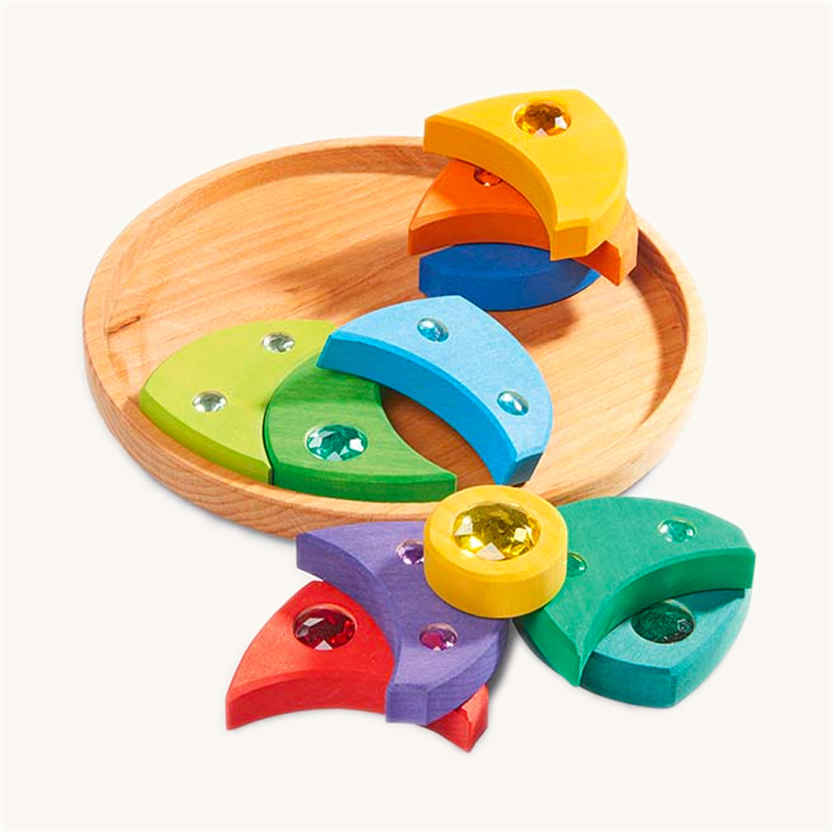 Gluckskafer wooden sparkling swirl toy blocks laid out next to its round wooden base on a beige background