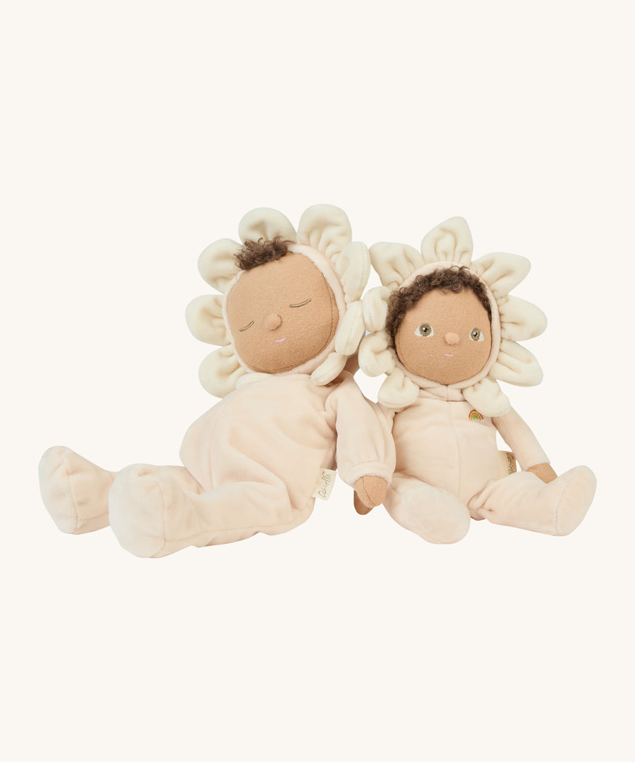 The two light cream dinkum dolls sitting next to eachother on a cream background.