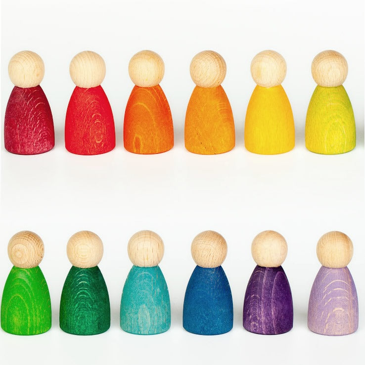 lined up in the colours of the rainbow around a black heart stone. A classic Waldorf peg doll toy for open ended play. White background.