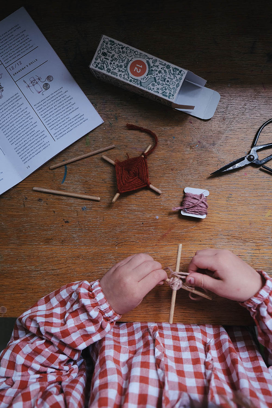 close up of child's hands knitting amulets