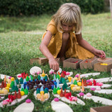 Close up of a girl playing with the Grapat handmade mandala toy pieces on the large petal blocks