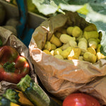 Close up of some Grapat eco-friendly wooden mandala tulips in a paper bag next to some vegetables