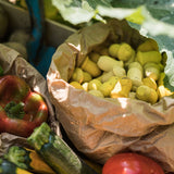 Close up of some Grapat eco-friendly wooden mandala tulips in a paper bag next to some vegetables