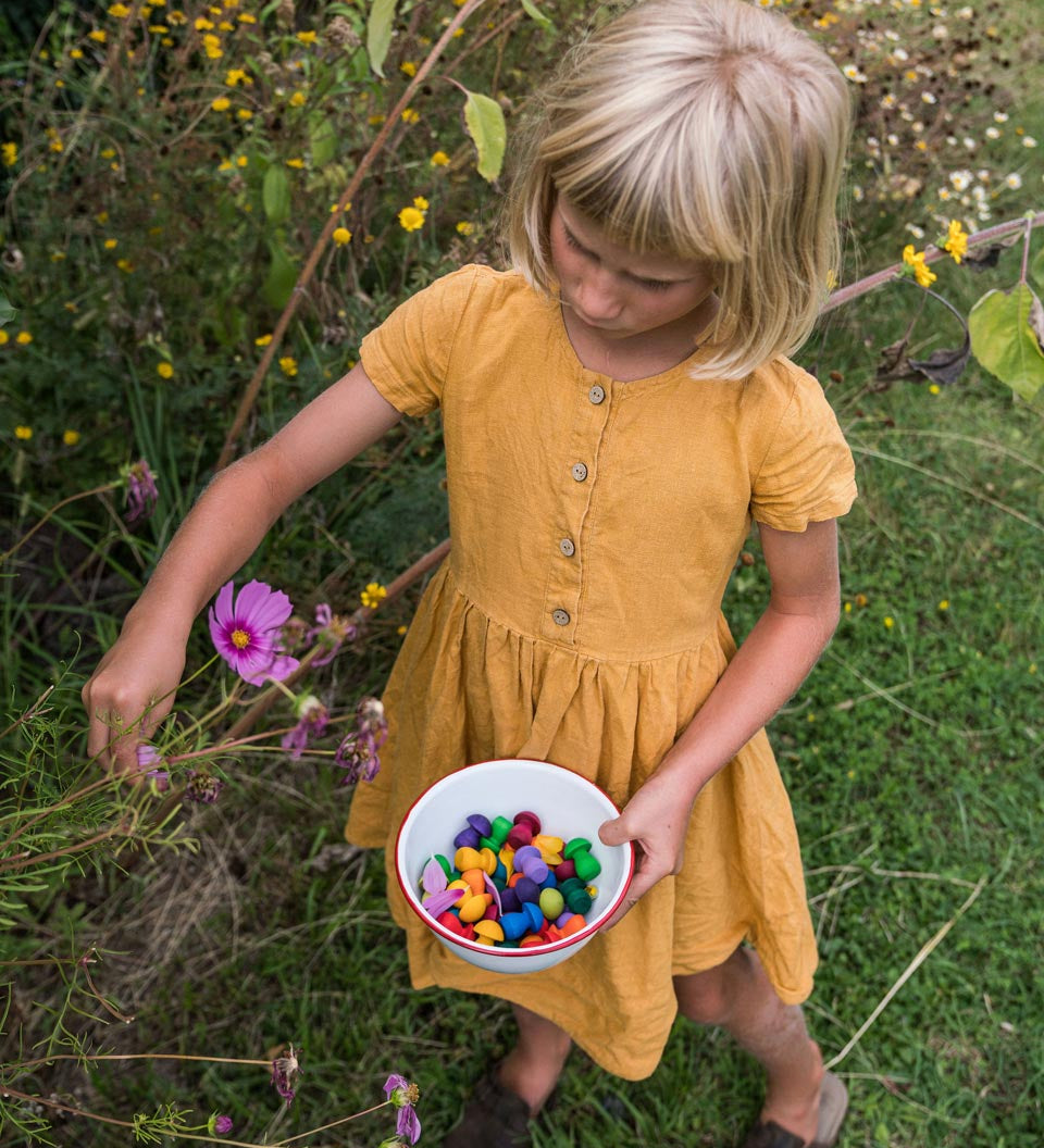 Girl picking flowers and holding a bowl of Grapat wooden mandala mushrooms