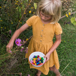 Girl picking flowers and holding a bowl of Grapat wooden mandala mushrooms