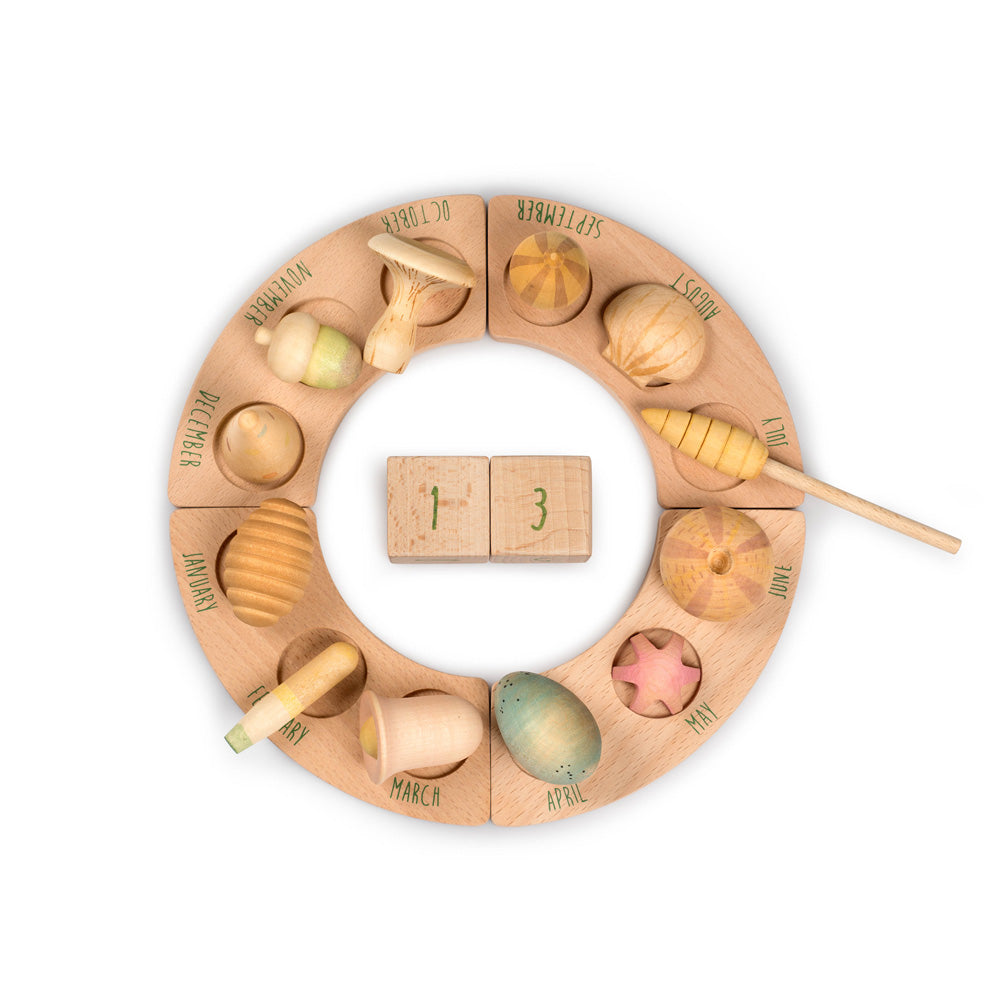 Grapat plastic-free wooden wonders toy pieces laid out on a perpetual calendar ring on a white background