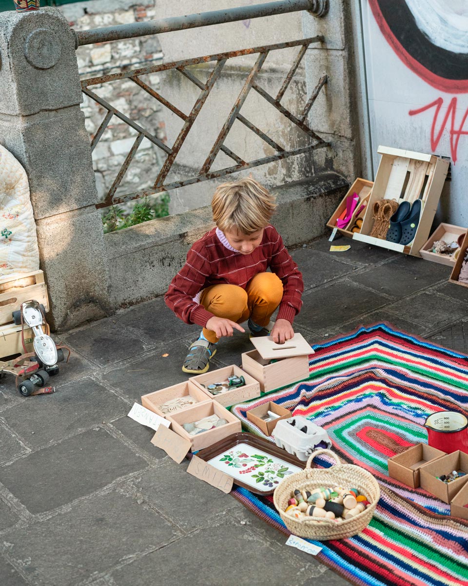 Young boy crouched down opening the lid of the Grapat Waldorf permanence box