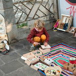 Young boy crouched down opening the lid of the Grapat Waldorf permanence box