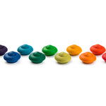 Pieces from the Grapat Waldorf Rainbow Flowers toy set lined up on a white background