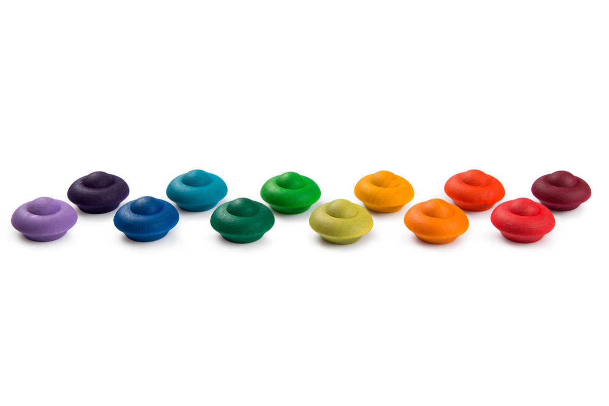 Pieces from the Grapat Waldorf Rainbow Flowers toy set lined up on a white background