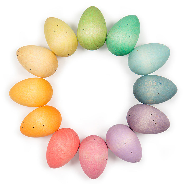 twelve wooden grapat happy eggs in pastel colours arranged into circle