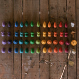 A child creating a beautiful mandala display with the Grapat Wooden Mandala Rainbow Snowflakes