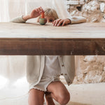 A child playing with the Grapat wooden mellow orange bird on a wooden table