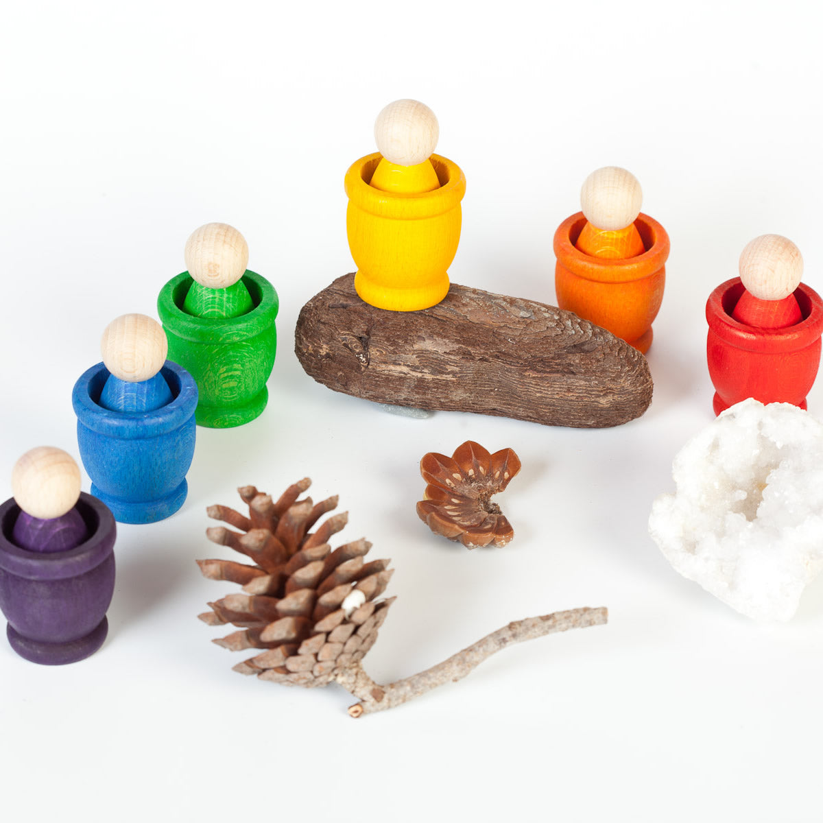 Grapat Nin Mates & Coins Wooden Toy Set. A rainbow coloured set of wooden Nin peg dolls within their corresponding Mates (cups) and other natural loose parts for open ended Waldorf and Montessori play. White background.