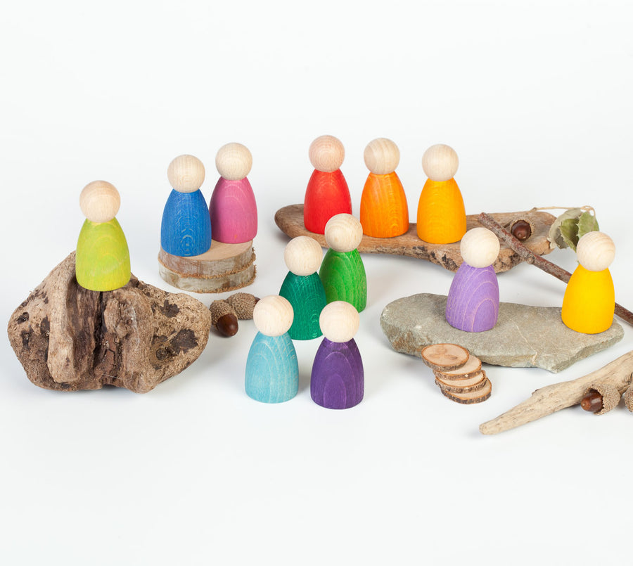 Grapat 12 Nins Wooden Peg Dolls lined up in the colours of the rainbow. A classic Waldorf peg doll toy for open ended play. White background.