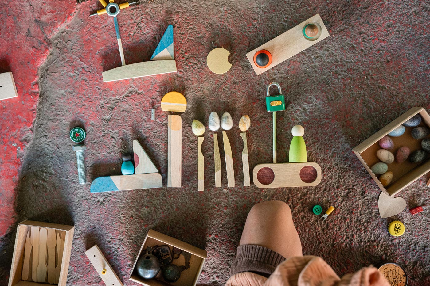 Close up of pieces from the Grapat happy place Waldorf toy set lined up of a stone floor